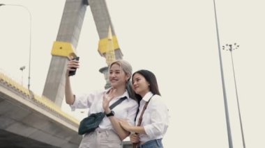 Mutlu Asyalı lezbiyen çiftler Tayland 'da seyahat eden arkadaşlarıyla görüntülü görüntülü sohbet. Tatilde eğlenen güzel genç kadınlar. LGBT kavramı.