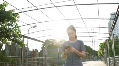 Güzel Asyalı sporcu kızlar koşudan sonra sosyal medyaya mesaj göndermek için akıllı telefonları kullanıyorlar. Gün batımında sokakta koşu yaşam tarzı..
