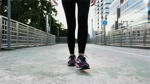 通りを歩いて若いアジアの女性選手の足を閉じます 日没時に路上でワークアウトのライフスタイルをジョギング 健康的なライフスタイル — ストック動画