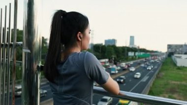 Çekici Asyalı bayan sporcular bir süre koştuktan sonra trafiğe bakarlar..