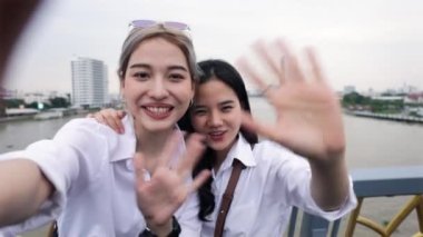 Mutlu Asyalı lezbiyen çiftler akıllı telefon kullanarak arkadaşlarıyla Tayland 'a seyahat ediyorlar. Tatilde eğlenen güzel genç kadınlar. LGBT kavramı.