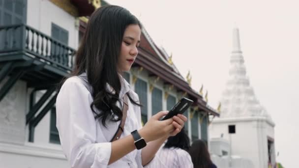 Junge Asiatin Mit Smartphone Während Sie Auf Der Straße Neben — Stockvideo
