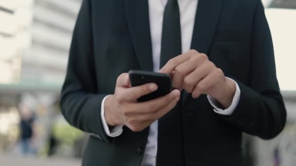 アジアのビジネスマンはスマートフォンを使用してソーシャルメディアを閲覧し オフィスの従業員にメッセージを送信します 友人とチャットしながらスマートフォンを画面に入力して閉じる手アジアの男 — ストック動画