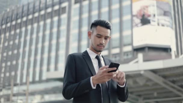 成功したビジネスマンだ アジアの男の勝者は幸せな楽しさを感じてスマートフォンを使用して保持しながら 良いニュースを祝う — ストック動画