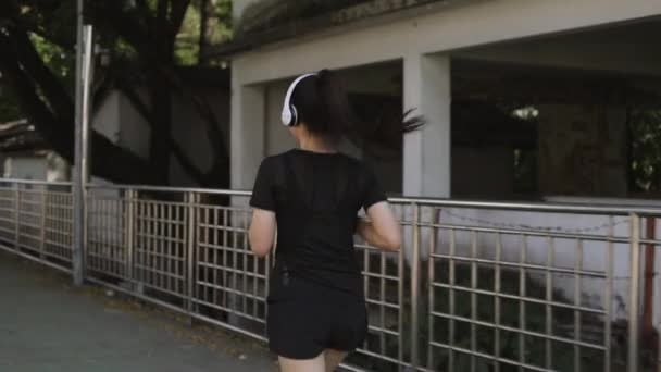 Aziatische Vrouwelijke Atleten Lopen Met Een Koptelefoon Met Behulp Van — Stockvideo
