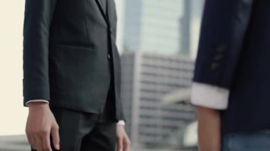 Asyalı iş adamlarının el sıkışması ortaklık anlaşması sabah büyük bir ofis binasının yakınında dikilirken yapılır..