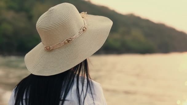 Привлекательная Азиатка Шляпе Шляпе Стоящая Пляже Смотрящая Красивый Закат — стоковое видео