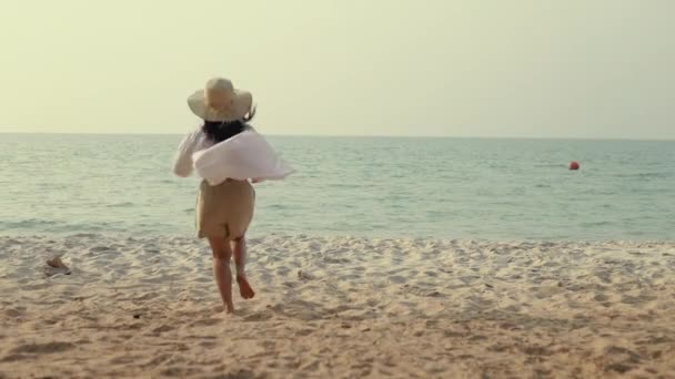 腕を上げてビーチに走っている幸せなアジアの女性は旅行の休日を祝います夏の素晴らしい美しい海の砂の景色日没 — ストック動画