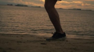 Yazın güzel bir gün batımında sahilde egzersiz yaparken ip atlayan beyaz atlet bacaklarını kapat. Sağlıklı spor yaşam tarzı konsepti.