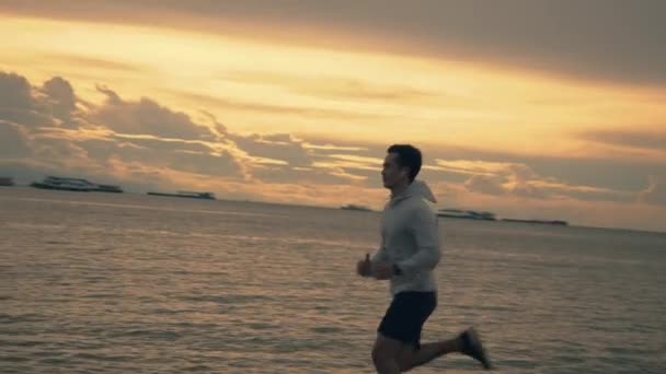 Atleta Joven Asiático Hombre Corriendo Junto Mar Mientras Hermoso Atardecer — Vídeo de stock