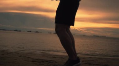 Çekici bir Asyalı koşucu, yaz aylarında güzel bir günbatımında sahilde ip atlayıp egzersiz yapıyor. Sağlıklı spor yaşam tarzı konsepti.