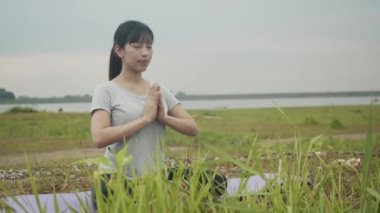 Meditasyonda oturan güzel Asyalı kadın güneş doğarken güzel dağların manzarasında tıbbın yoga pranayama dengesini sağlıyor. Sağlık ve Sıhhat kavramı.