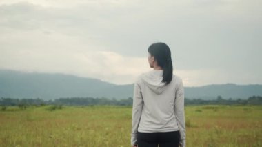 Atletik koşucu Asyalı kadın koşup dağ manzarasına baktıktan sonra dinleniyor. Koşu yaşam tarzı sağlıklı yaşam tarzı.