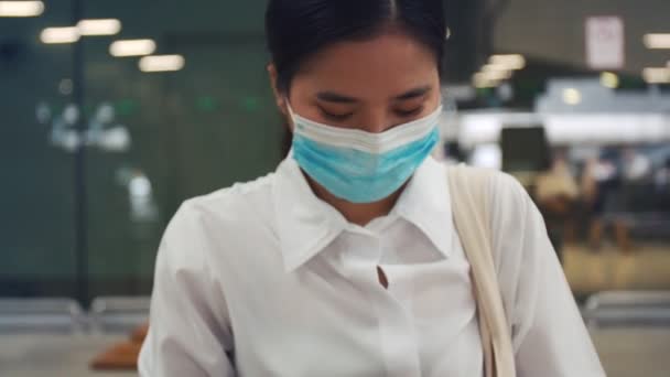 Perempuan Muda Mengenakan Masker Bedah Dan Menggunakan Smartphone Terminal Bandara — Stok Video