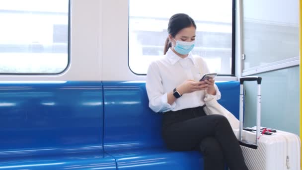 여자는 보호를 마스크를 열차를 여행하면서 거리를 유지하면서 스마트폰을 — 비디오