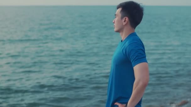 Man Runner Néz Tengerre Néző Miközben Áll Strandon Ázsiai Sportoló — Stock videók