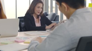 Asyalı iş kadını, iş için tablet kullanıyor toplantı odasında otururken veri topluyor, Kafkasyalı iş adamları modern ofisteki meslektaşlarına beyin fırtınası yapıyor, iş adamları birlikte çalışıyor..