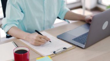 Asyalı adam küçük işletme sahibi covid-19 salgını sırasında ev ofisindeki paket kutusunu kontrol ediyor..