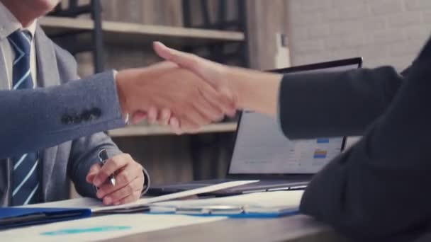 アジアのビジネスマンがオフィスにいる間に手を振るパートナーシップ契約ビジネスをする 幸せな自信は新しい仕事で雇われる握手の雇用者を受け入れる — ストック動画