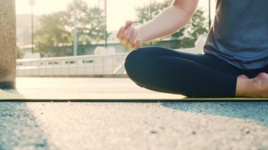 Meditasyonda oturan Asyalı kadın ellerini kapat. Yoga pozisyonu al. Pranayama dengesi güzel. Sağlık ve Sıhhat kavramı.