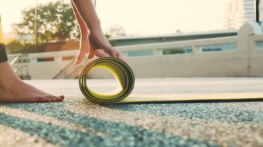 Parktaki yoga dersinden sonra Asyalı kadın yoga minderinin ellerini kapat..