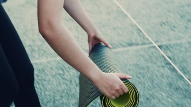 亚洲女子在公园上完瑜伽课后翻滚瑜伽垫的特写镜头 — 图库视频影像