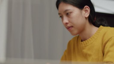 Pandemik karantina sırasında evinde dizüstü bilgisayarla çalışan beyaz bir kadın..