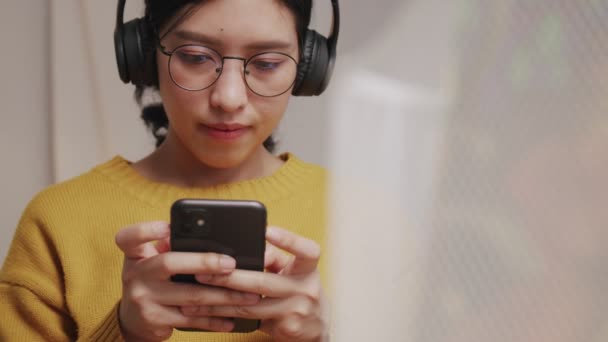 Jonge Vrouw Typt Bericht Mobiel Luistert Naar Muziek Met Draadloze — Stockvideo