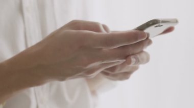 Kapalı eller yakışıklı adam COVID-19 salgını sırasında sosyal medyada arkadaşlarıyla mesajlaşarak akıllı telefon yazma kullanıyor..