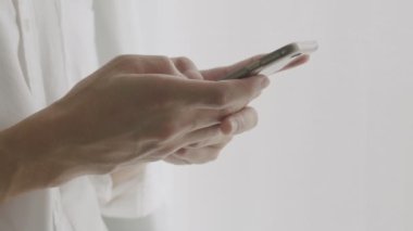 Akıllı telefon kullanarak ellerini kapat. Sosyal medyada arkadaşlarınla sohbet ederken evde pencerenin yanında dur..
