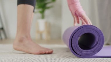 Ellerini kapat, kadın COVID-19 salgını sırasında spor salonu veya yoga başlamadan önce paspasları açıyor..