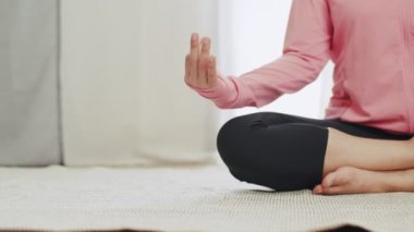 Çekici genç kadın COVID-19 salgını sırasında evde yarım lotus pozu veriyor..