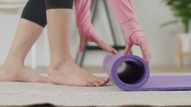 在家庭健身或瑜伽结束后 紧紧抓住高加索女子滚动运动垫的手 — 图库视频影像