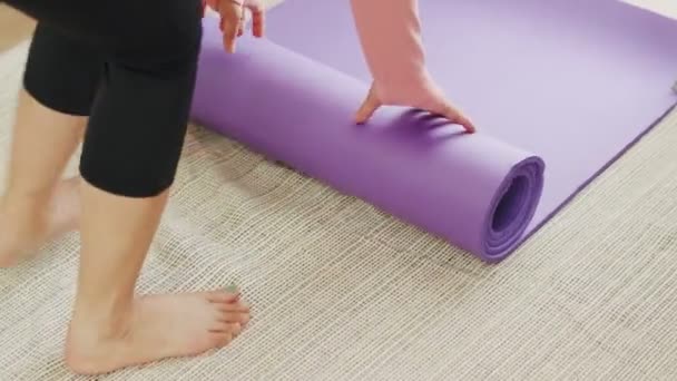在开始健身或在家练瑜伽之前 要紧握着高加索女人展开运动垫的手 — 图库视频影像