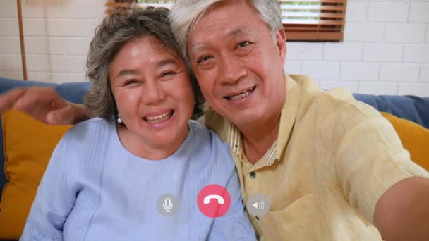 亚洲的一对老夫妇正在用智能手机进行视频聊天 在家里沙发上分享社交媒体的交流 慢动作 — 图库视频影像