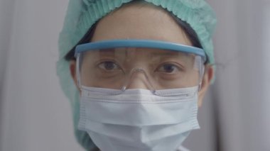 COVID-19 salgını sırasında hastanede çalışan yüzü maskeli Asyalı doktor ya da hemşire portreyi kapatın..