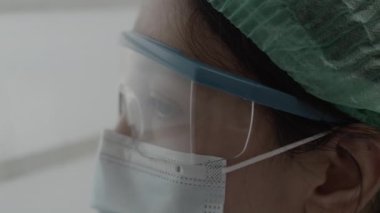 Coronavirus salgını sırasında hastanede dinlenirken yorgun düşmüş ya da pencereden dışarı bakan bir doktor ya da hemşire. Sağlık çalışanları koruma altında..