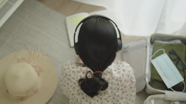 Путешествуйте Азиатка Лежит Полу Спальне Читая Книгу Слушая Музыку Женщина — стоковое видео