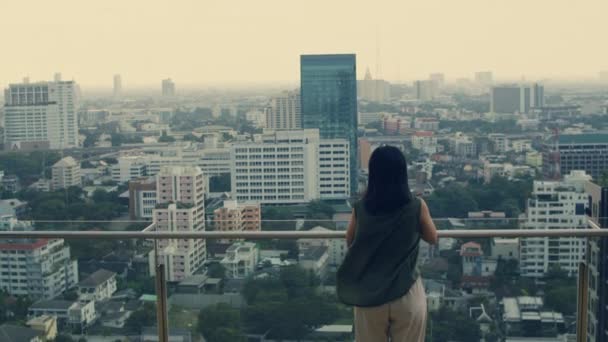 屋上に立ちながらスマホを使うアジア人女性 — ストック動画
