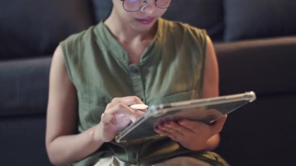 Asiática Mujer Usando Gafas Escribe Artículos Tableta Digital Mientras Está — Vídeos de Stock