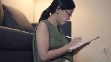 Asyalı bir kadın her gece tabletiyle evde çalışıyor..