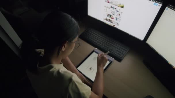 年轻的亚洲人晚上在家里的平板电脑上画着她的作品 滚动着新闻素材 搜寻着她工作计划的在线信息数据 — 图库视频影像