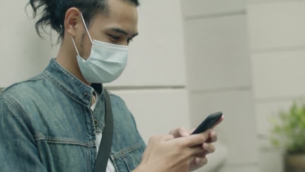 Close Jovem Asiático Vestindo Uma Máscara Cirúrgica Usando Smartphone Enquanto — Vídeo de Stock