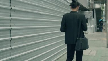 Genç Asyalı işadamı sabah ofise doğru yürüyor..