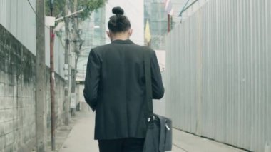 Çekici bir işadamı sabah ofise yürürken akıllı telefon kullanıyor..