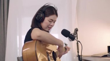 Güzel bir Asyalı kadın gitar çalmayı öğreniyor ve evinde şarkı söylüyor. Müzisyen yeni bir şarkı konsepti yaratmaya çalışıyor..