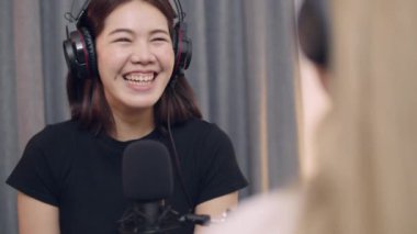 İki Asyalı genç kadın gazetecinin ve nüfuzlu kişilerin konuşmaları podcast ve canlı yayını stüdyo işyerinde tartışıyor..