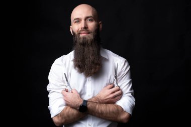 Siyah arka planda uzun sakallı ve makaslı berber.