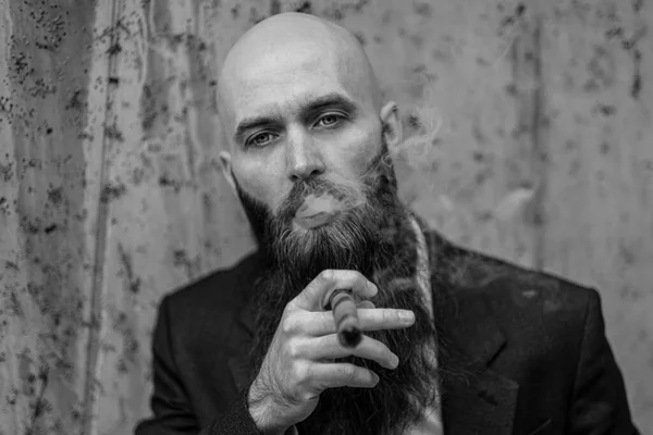 Elegant bearded man with cigar.