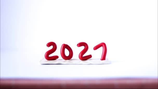 Beyaz arka planda kırmızı plastikçiden 2021 numara geliyor. 2 numara bir numaranın yerine geçiyor. — Stok video